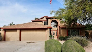 A single-story house with a garage, a front door, and a small porch area.