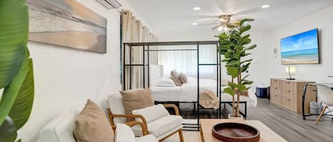 Une chambre d’hôtel moderne équipée d’un lit, d’un coin salon et d’une télévision.