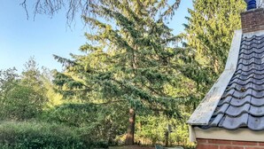 A patio area with a brick wall, a tiled roof, and a table with chairs. - Amazing home in Vledder with WiFi (Vledder)