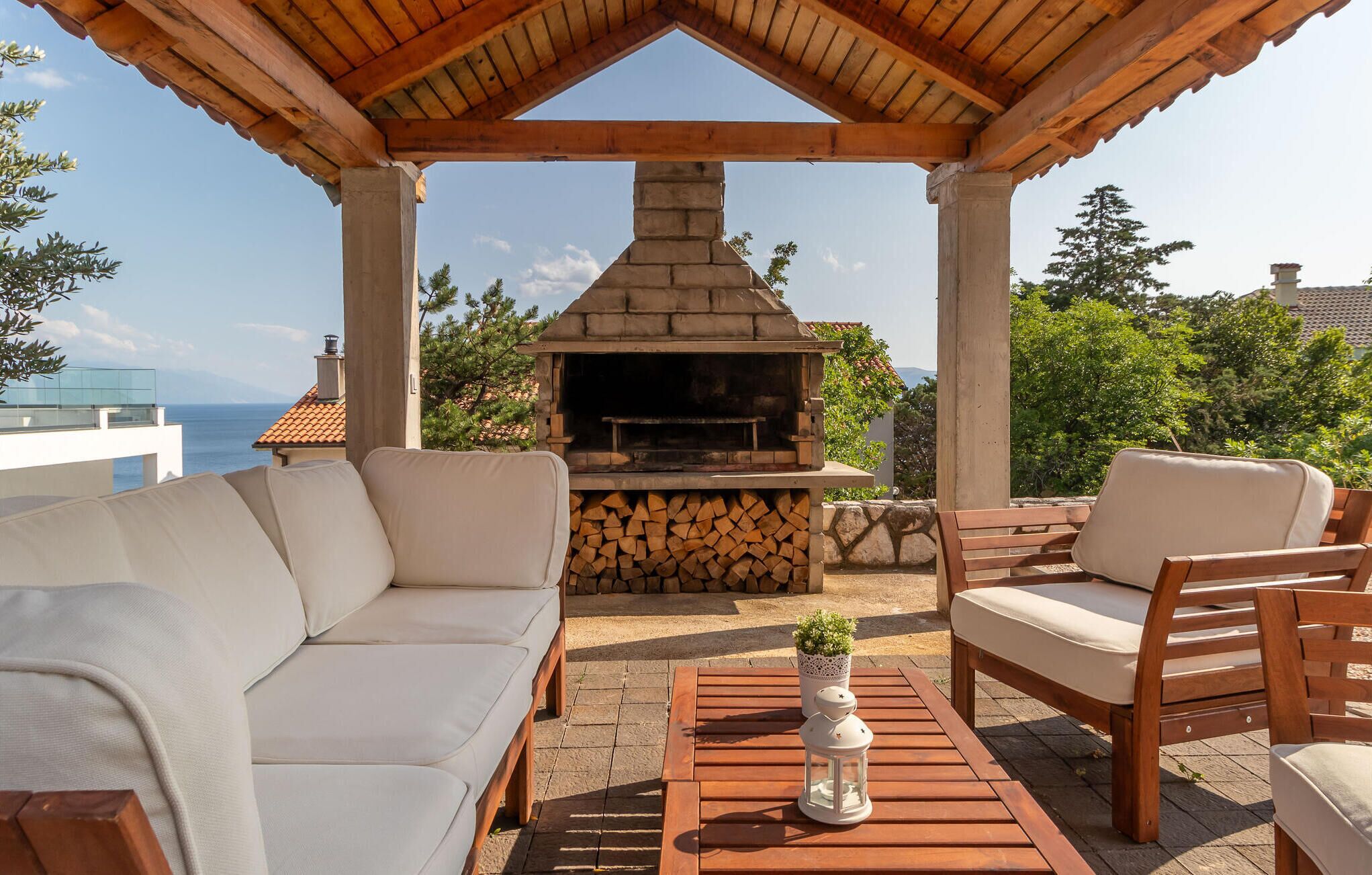 Un espacio al aire libre con una chimenea de piedra, un sofá y una mesa con un farol.