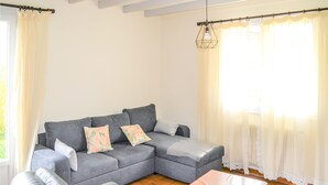 A living room with a grey sofa, a wooden coffee table, and a green armchair. - 2 bedroom awesome home in Langon (Langon)