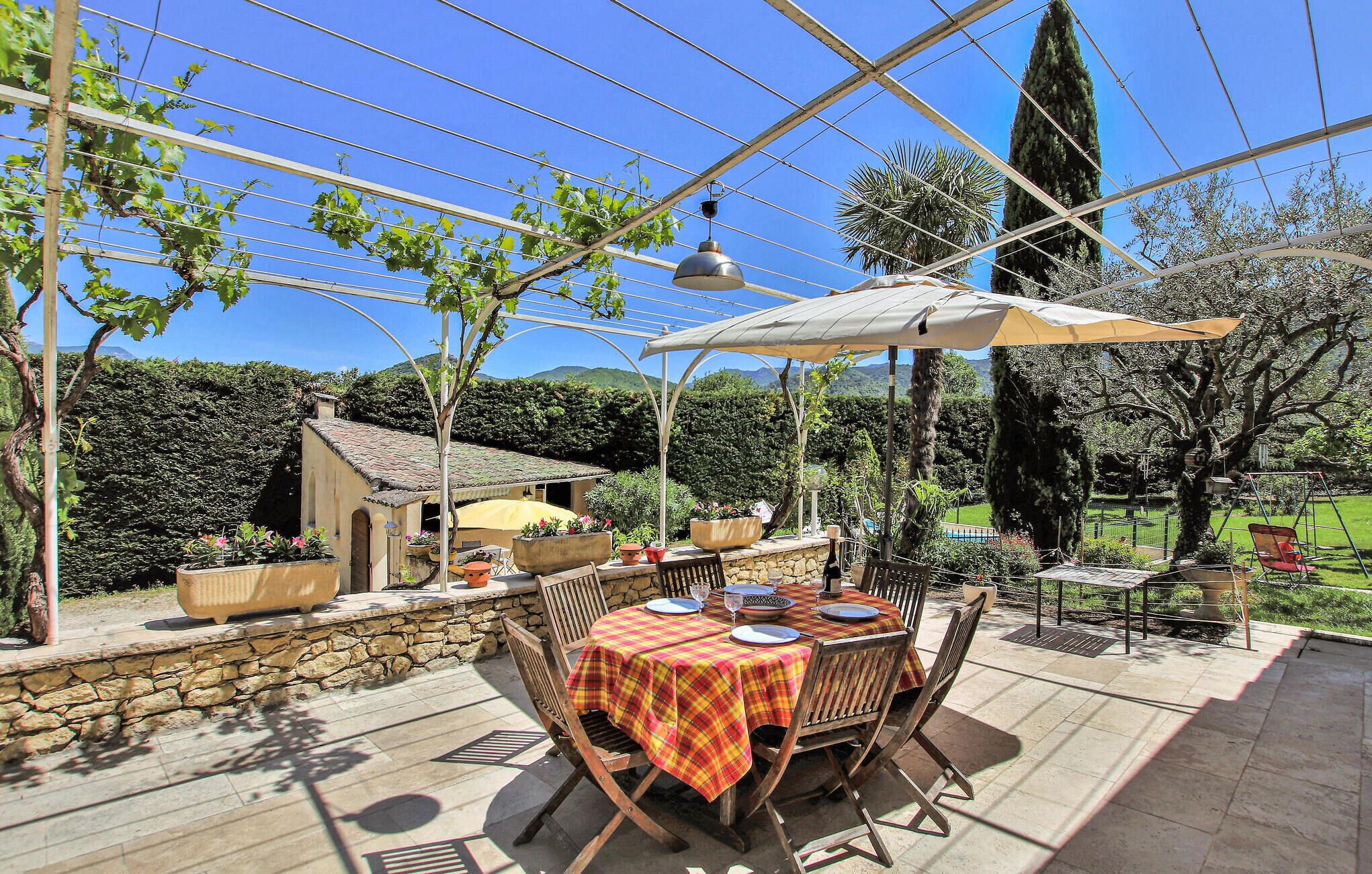 Eine Terrassensitzgruppe im Freien mit Tisch, gedeckt für das Essen, umgeben von Blumentöpfen und einer Steinmauer.