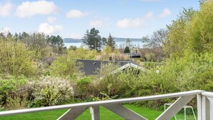 Ett bostadsområde med utsikt över en sjö eller ett annat vattendrag och avlägsna kullar.