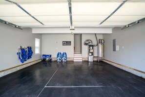 A spacious garage with a polished floor, a white ceiling, and a sign that reads "The Beach Haven."