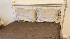 A bed with a brown quilt, white headboard, and a wooden floor. - Cozy Peaceful Convenient Sweet Home 1 minute to all places 優雅方便，私用衛浴， 高速出口一分鐘。 (Hacienda Heights)