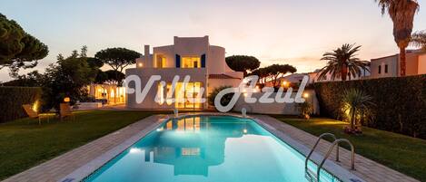 Relax by the serene pool surrounded by lush lawns and mature trees.