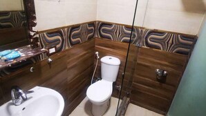Un baño con lavamanos, inodoro y ducha.