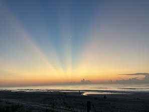 A beach with a sunset, waves, and a distant city skyline. - First Floor Home, No Stairs, Only One Block From The Ocean (Myrtle Beach)