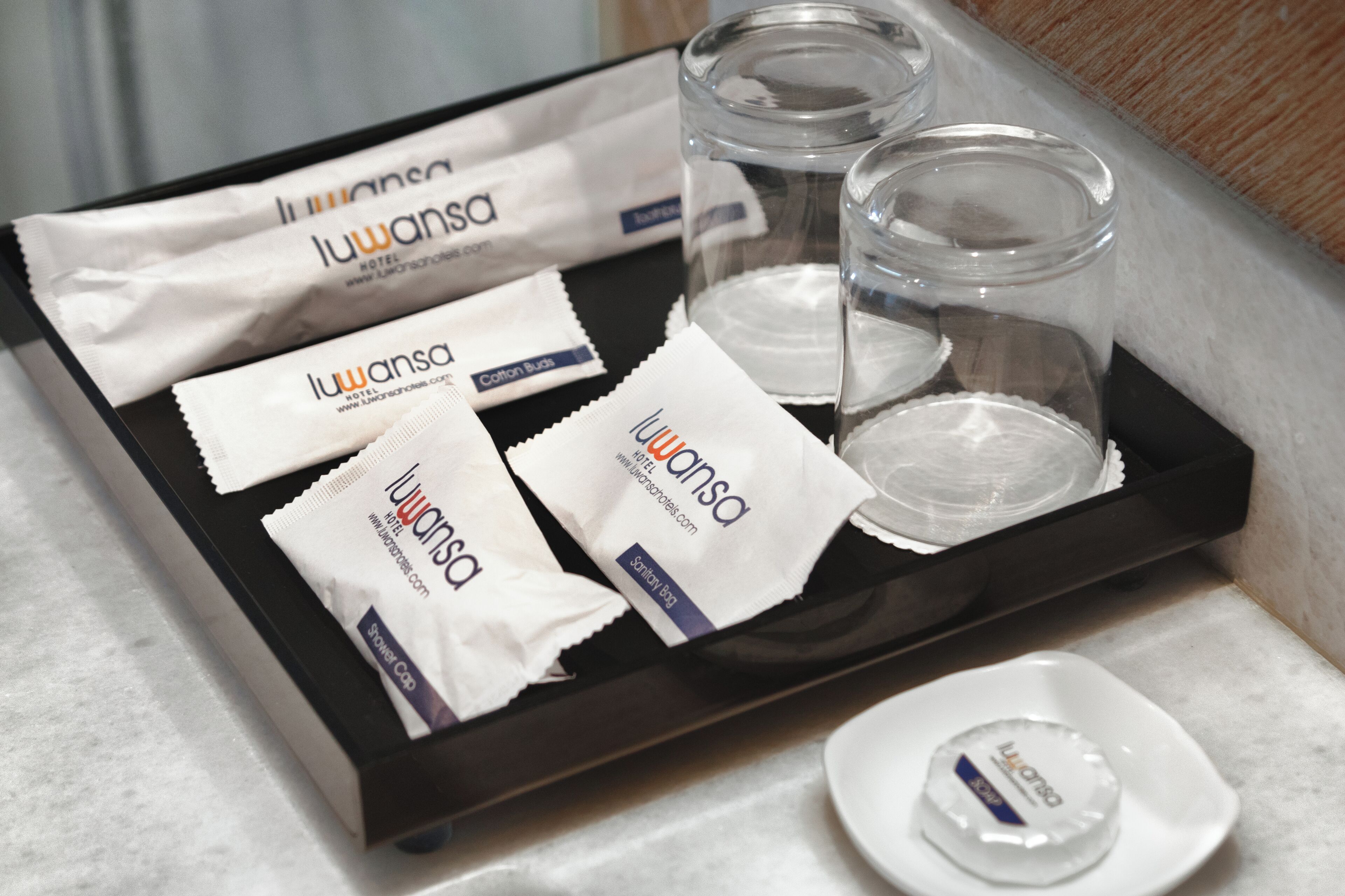 A tray with toiletries including cotton buds, a toothbrush, and a soap dish.