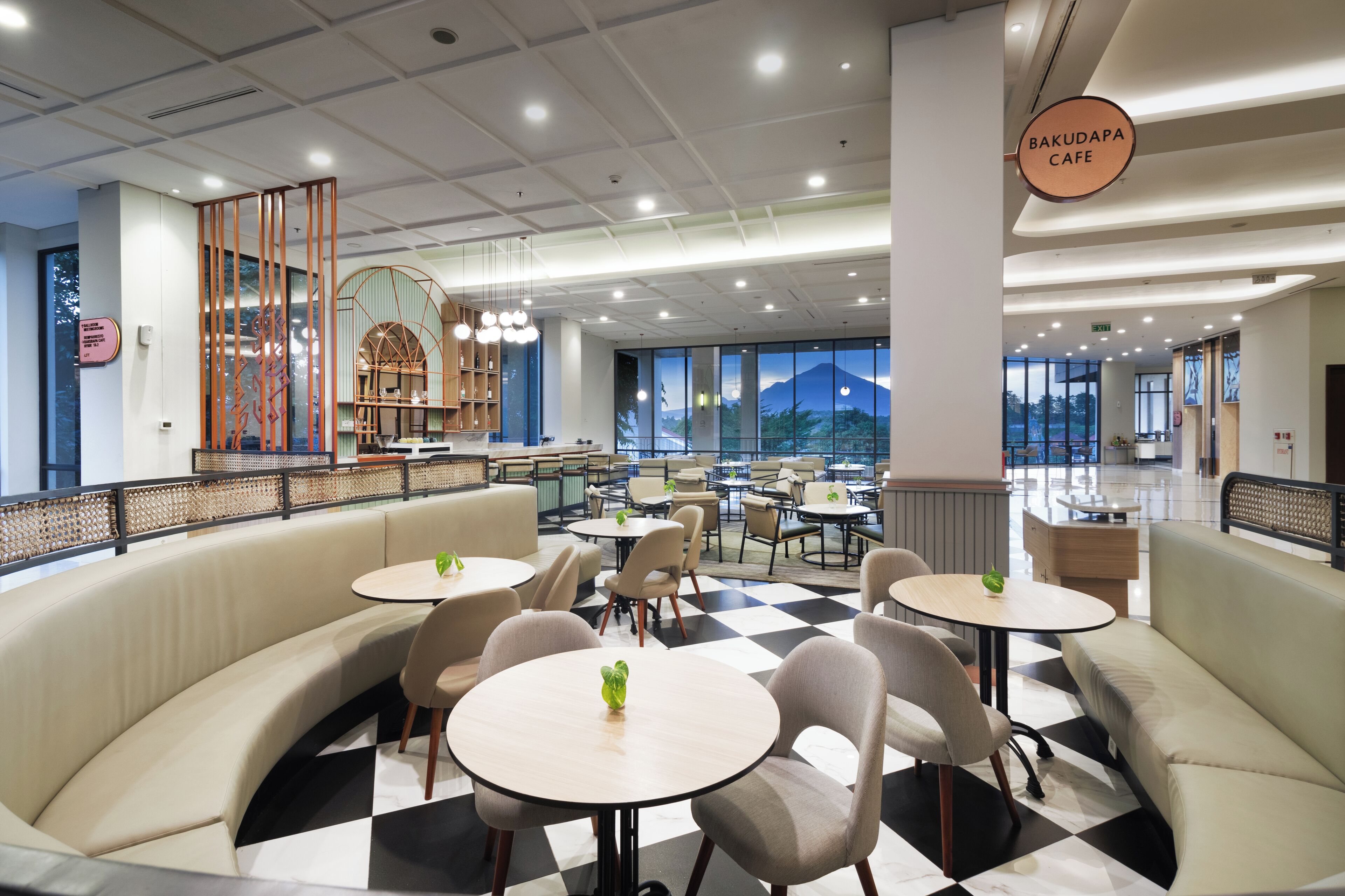 A modern cafe with a checkered floor, round tables, and cushioned seating areas.