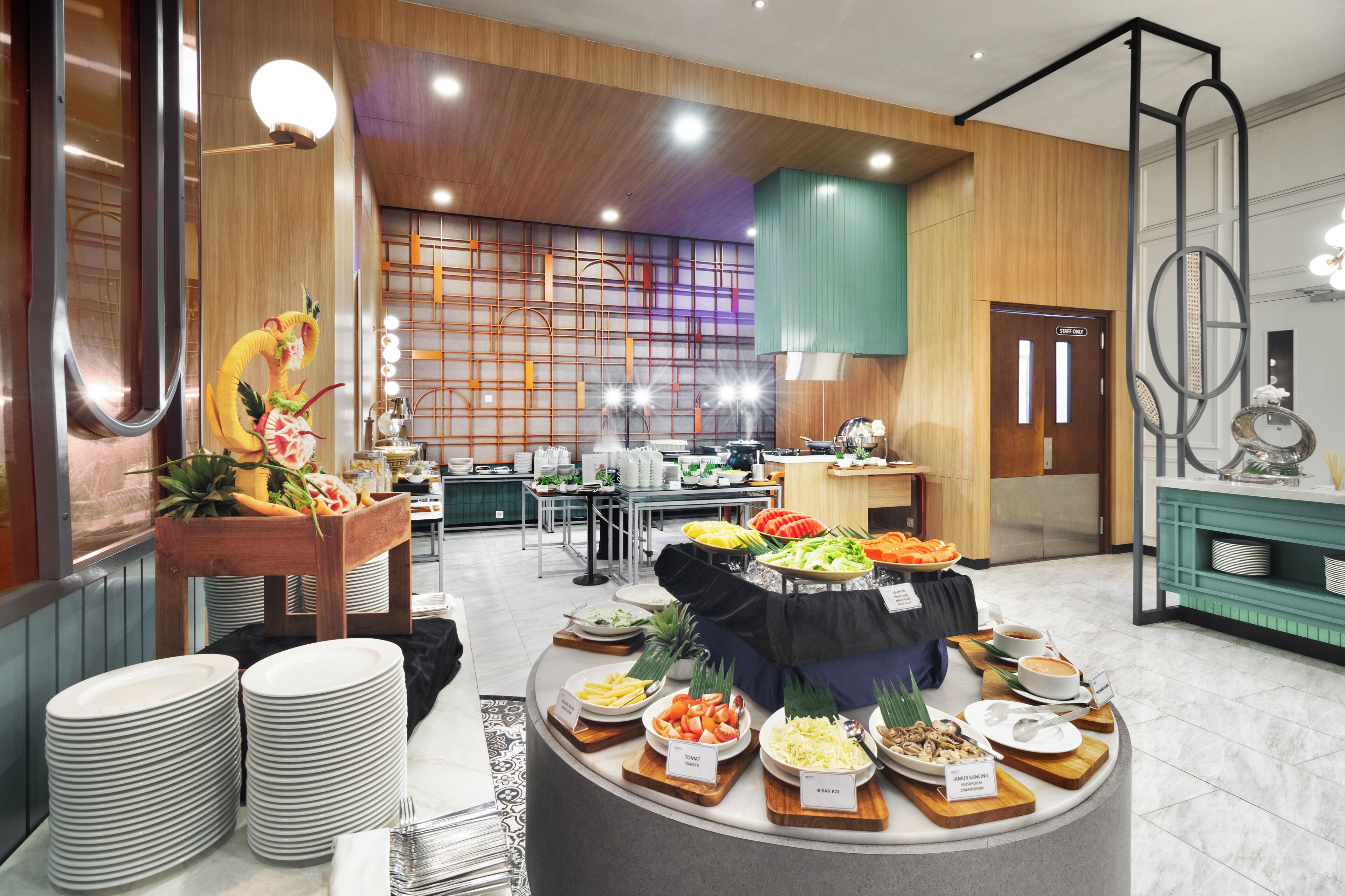 Un área de buffet con varias estaciones de comida, una recepción y una puerta para personal.