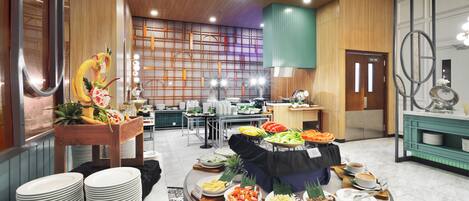 A buffet area with various food stations, a reception desk, and a staff-only door.