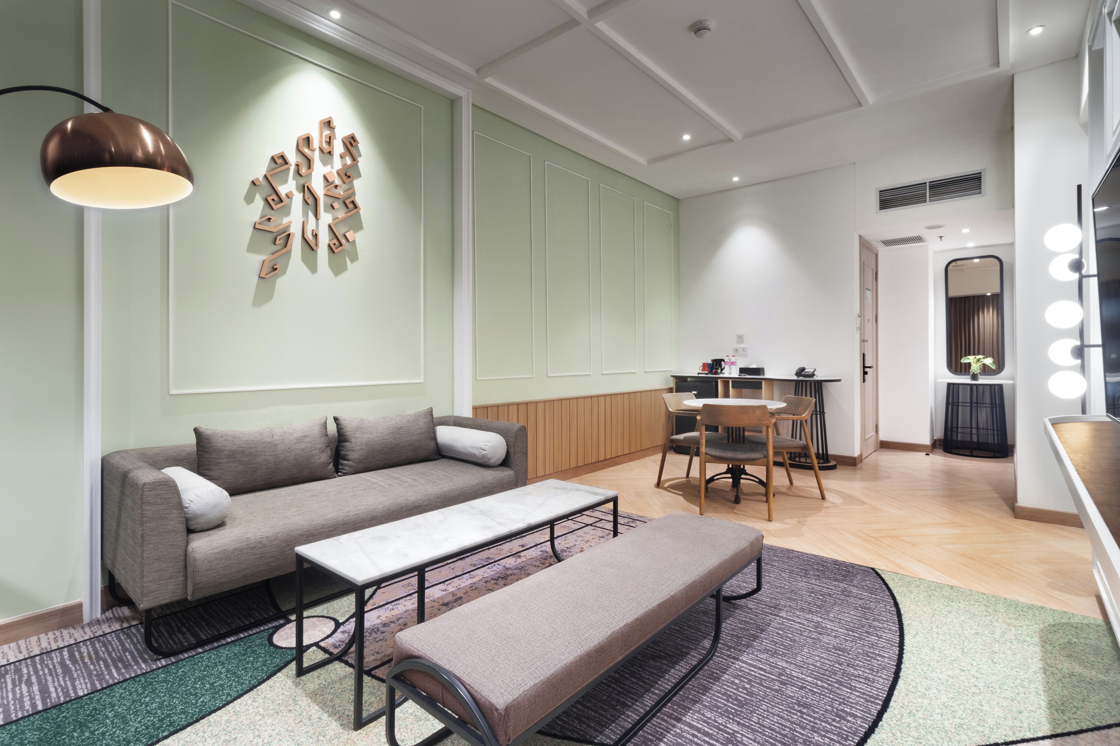 A modern living room with a sofa, bench, and a dining area with a table and chairs.