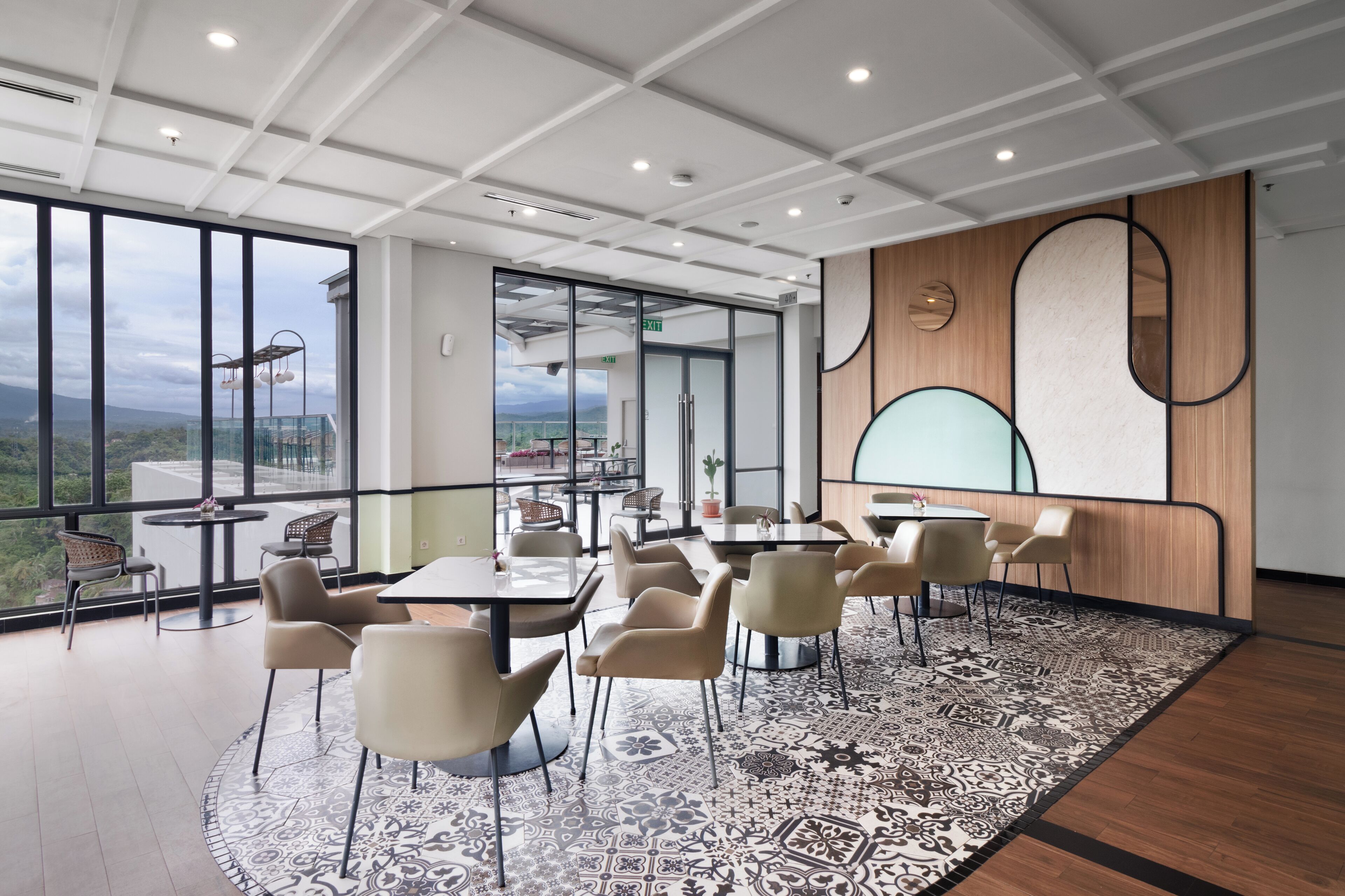 Uma sala de conferências moderna, com grandes janelas, carpete estampado e vista para o exterior.