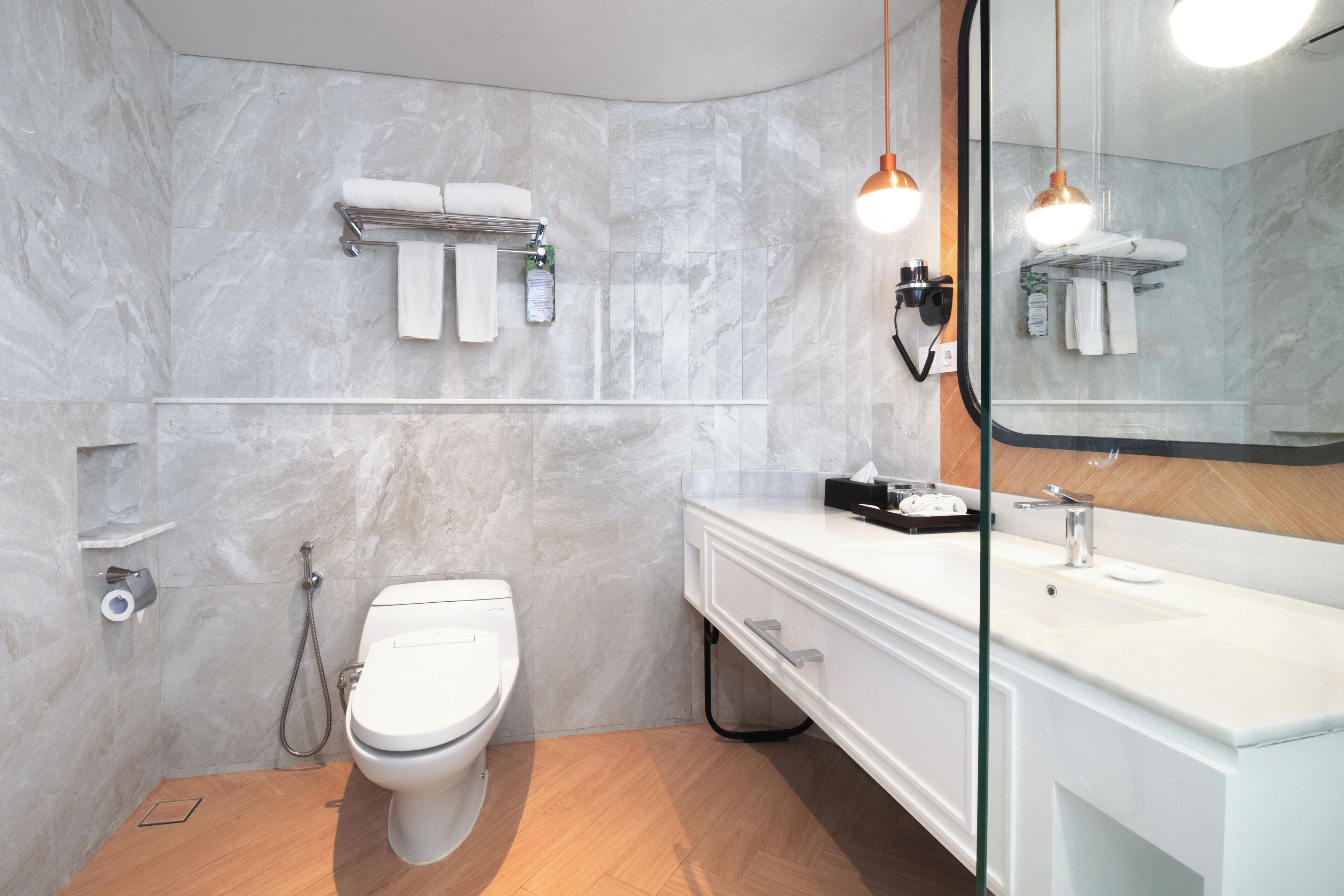 A modern bathroom with a toilet, sink, and towel rack.