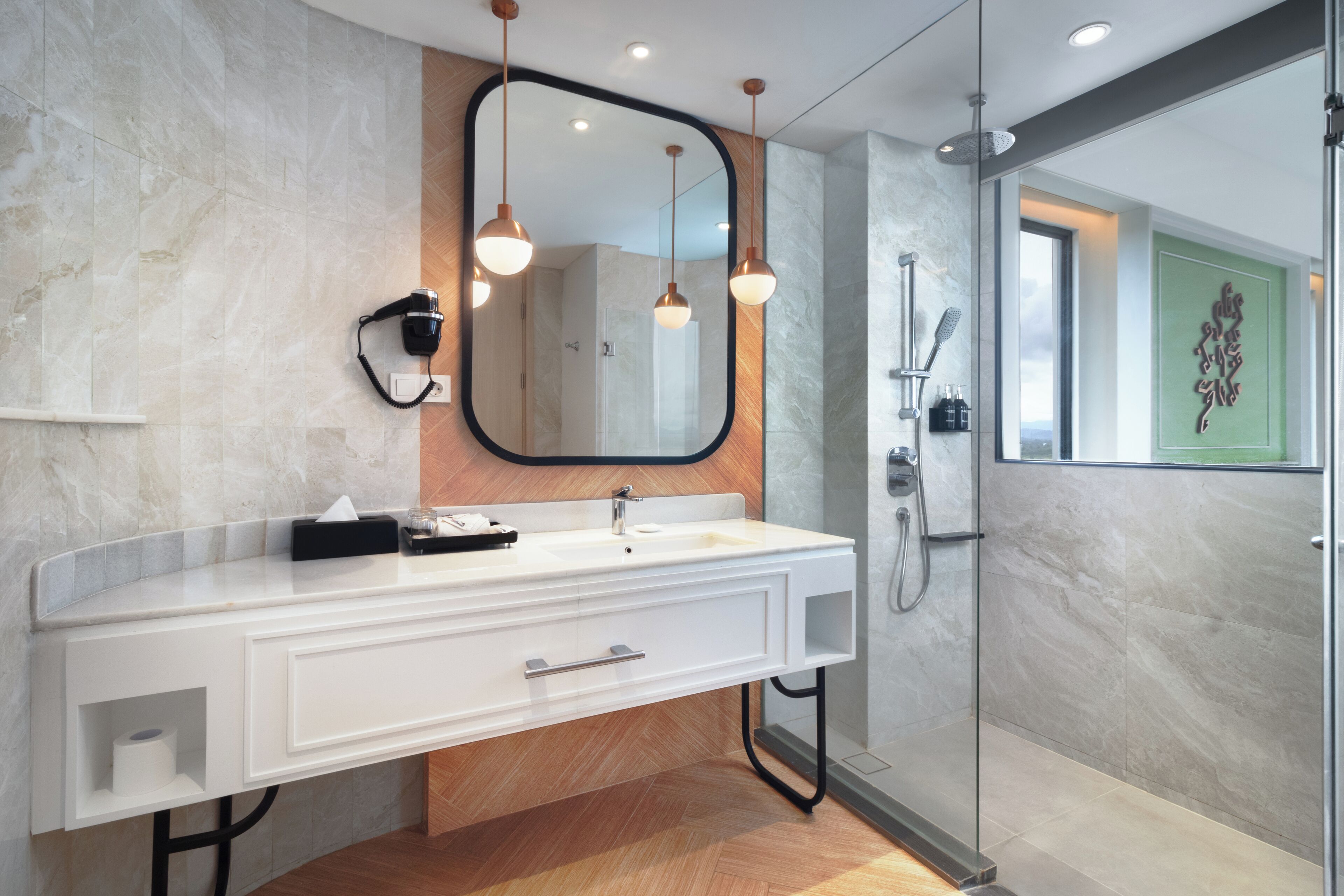 A modern bathroom with a large mirror, a white vanity, and a glass-enclosed shower.