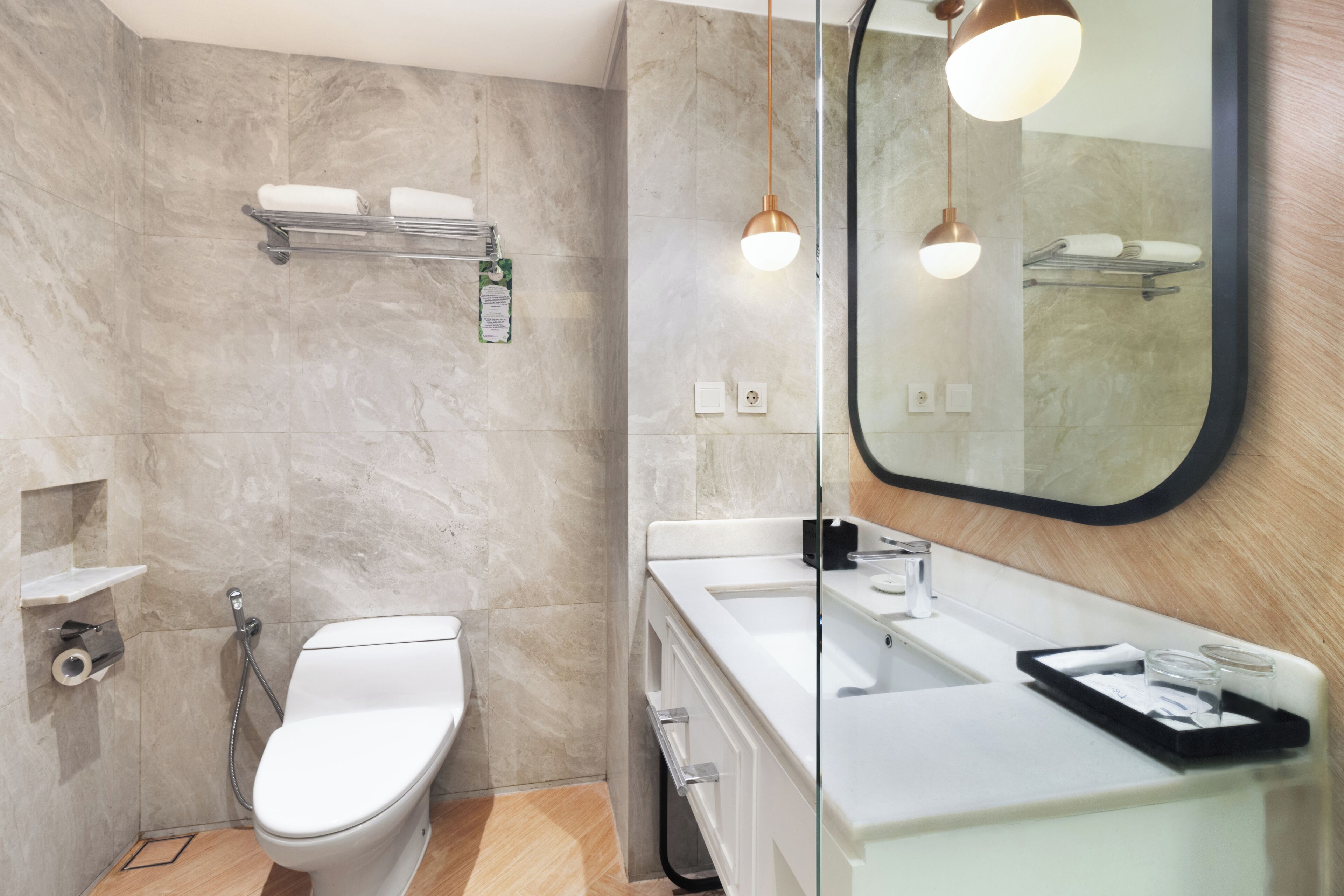 A modern bathroom with a toilet, sink, and mirror.