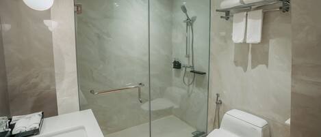 A modern bathroom with a glass-enclosed shower, a white toilet, and a glass-enclosed bathtub.