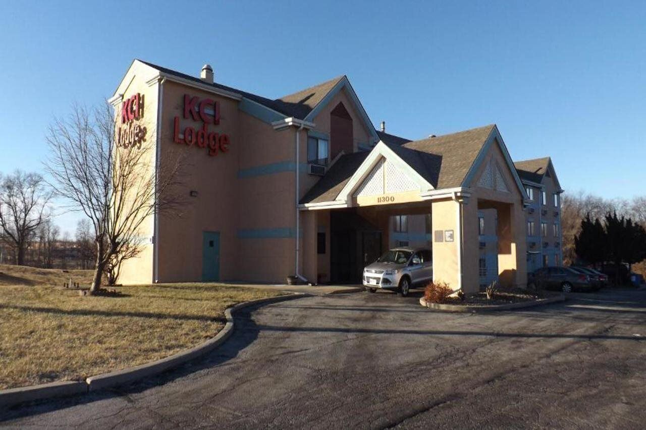 A KCH Lodge building with a parking lot and a single car parked in front.