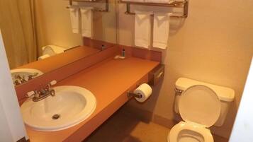 A bathroom with a sink, toilet, and towel rack.