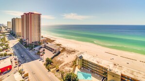 A coastal hotel with a pool, beachfront view, and adjacent road.