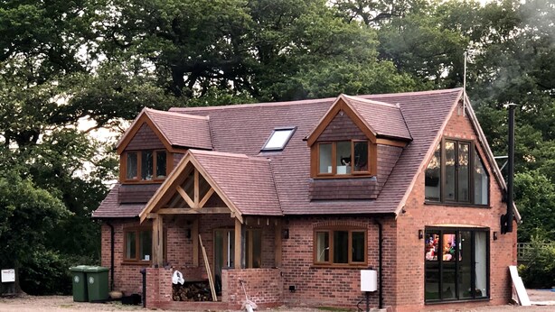 A two-story house with a pitched roof, brick walls, and a visible chimney. - Private Room - Sleeps 2 - Private Entry - Parking (Solihull)