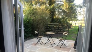An outdoor patio with stone flooring, two wooden tables, and four chairs. - Private Room - Sleeps 2 - Private Entry - Parking (Solihull)