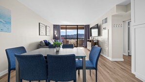 A modern living room with a dining area, large windows, and a view of mountains. - Renovated - Diamond Head and Ocean Views! - FREE Parking - 1 Block to Beach (Honolulu)