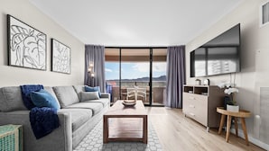 A modern living room with a sofa, coffee table, and artwork on the walls. - Renovated - Diamond Head and Ocean Views! - FREE Parking - 1 Block to Beach (Honolulu)