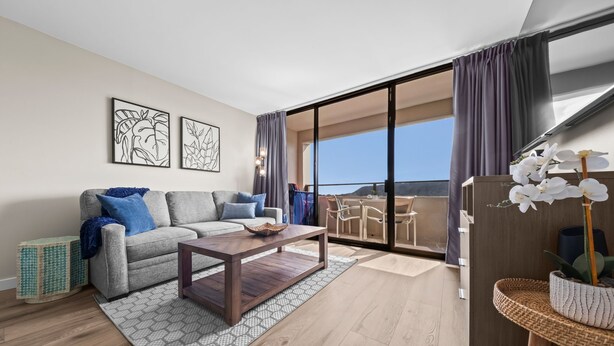 A modern living room with a sofa, coffee table, and artwork on the wall. - Renovated - Diamond Head and Ocean Views! - FREE Parking - 1 Block to Beach (Honolulu)