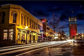 Experience the vibrant energy of this bustling urban street, lined with a mix of classic and modern architecture.