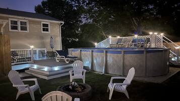 Ein Garten mit Whirlpool, Sitzgelegenheiten im Freien und einer Terrasse.