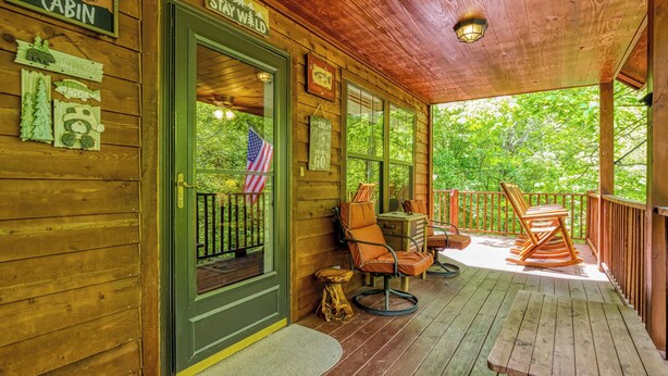 A wooden cabin with a porch, a welcome sign, and a sign indicating the cabin is for sale. - Cozy Cabin Hot tub Firepit Game Room Pool Table Gas Fireplace 5 min to GB-PF (Sevierville)