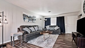 Een moderne woonkamer met een modulaire bank, een salontafel en een tv-meubel.