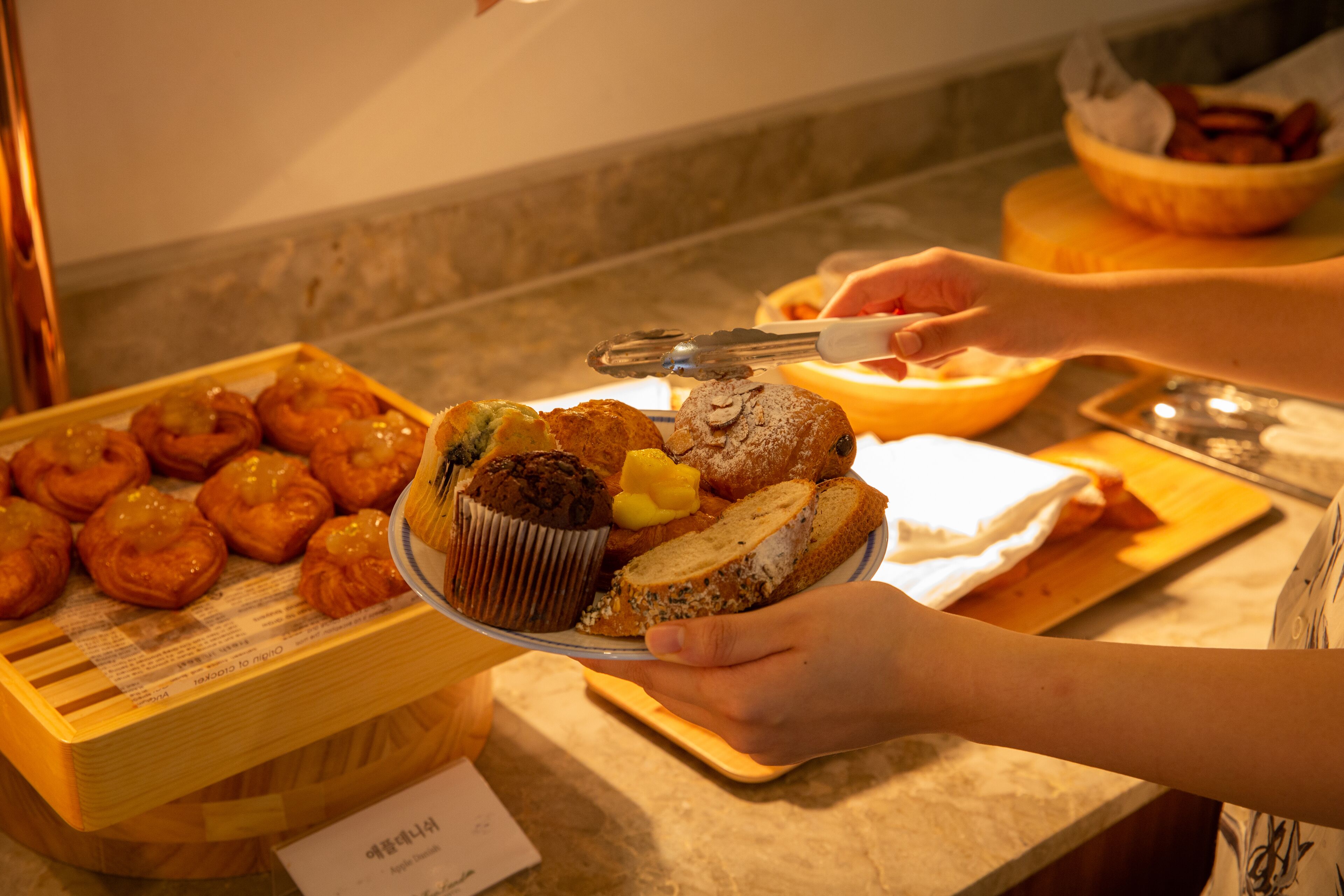 A buffet with various baked goods including muffins and pastries.