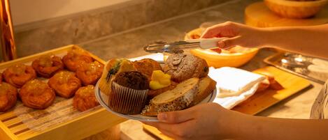 A buffet with various baked goods including muffins and pastries.