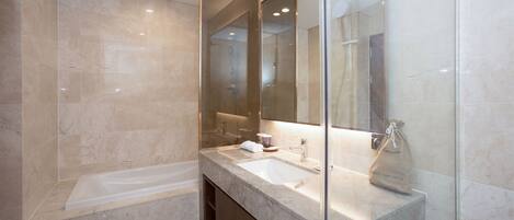 A modern bathroom with a large mirror, a bathtub, and a sink.