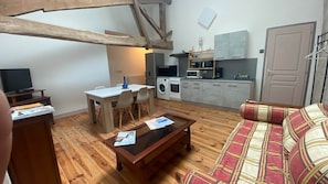 Un espacio habitable compacto con comedor, cocina y zona de estar.