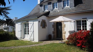 Et toetagers hus med en stenfassade, en stor hoveddør og en lille veranda.