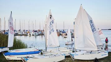 A marina with several small sailboats docked, some with visible registration numbers.