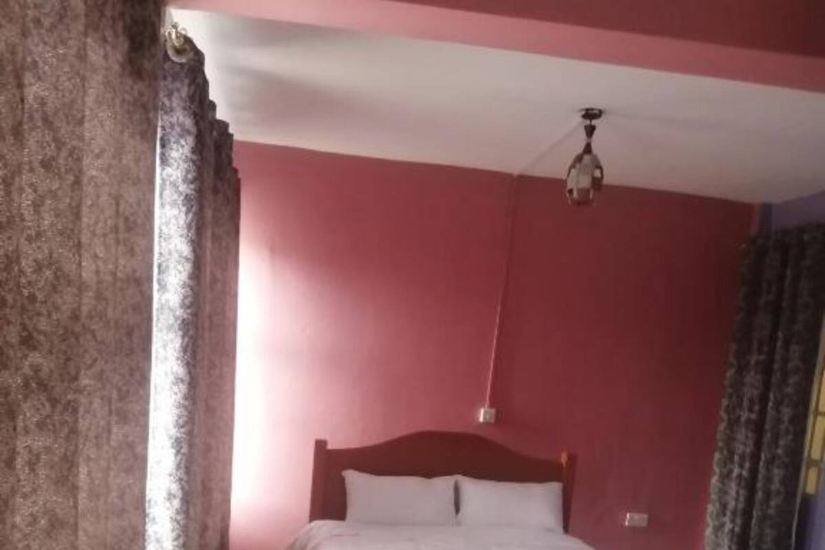 A bedroom with a wooden bed, white bedding, and a ceiling fan.