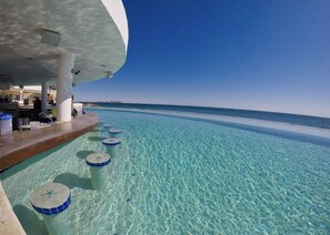 Ein klarer Blick auf einen Infinity-Pool mit Bar und Meerblick.