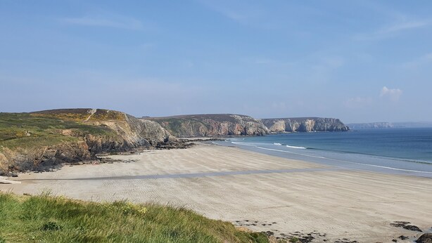 Eine Küstenlandschaft mit Klippen und einem Sandstrand.