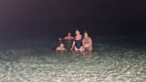 Four people in a shallow water body, possibly a pool or beach at night. - Villa AURORA, beautiful sea view! 400mt from the sandy beach. (Lizzano)