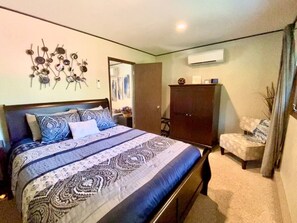 A bedroom with a bed, a wardrobe, and an air conditioning unit. - CdA Hotspot - Hot Tub, Pool, & Sauna (Coeur d Alene)