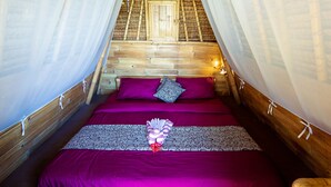 A room with a wooden ceiling and a bed with purple bedding and a decorative pillow. - Taman Asta Gangga by ecommerceloka (Sidemen)
