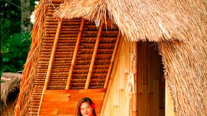 A rustic wooden hut with a thatched roof, a wooden door, and a bench outside. - Taman Asta Gangga by ecommerceloka (Sidemen)