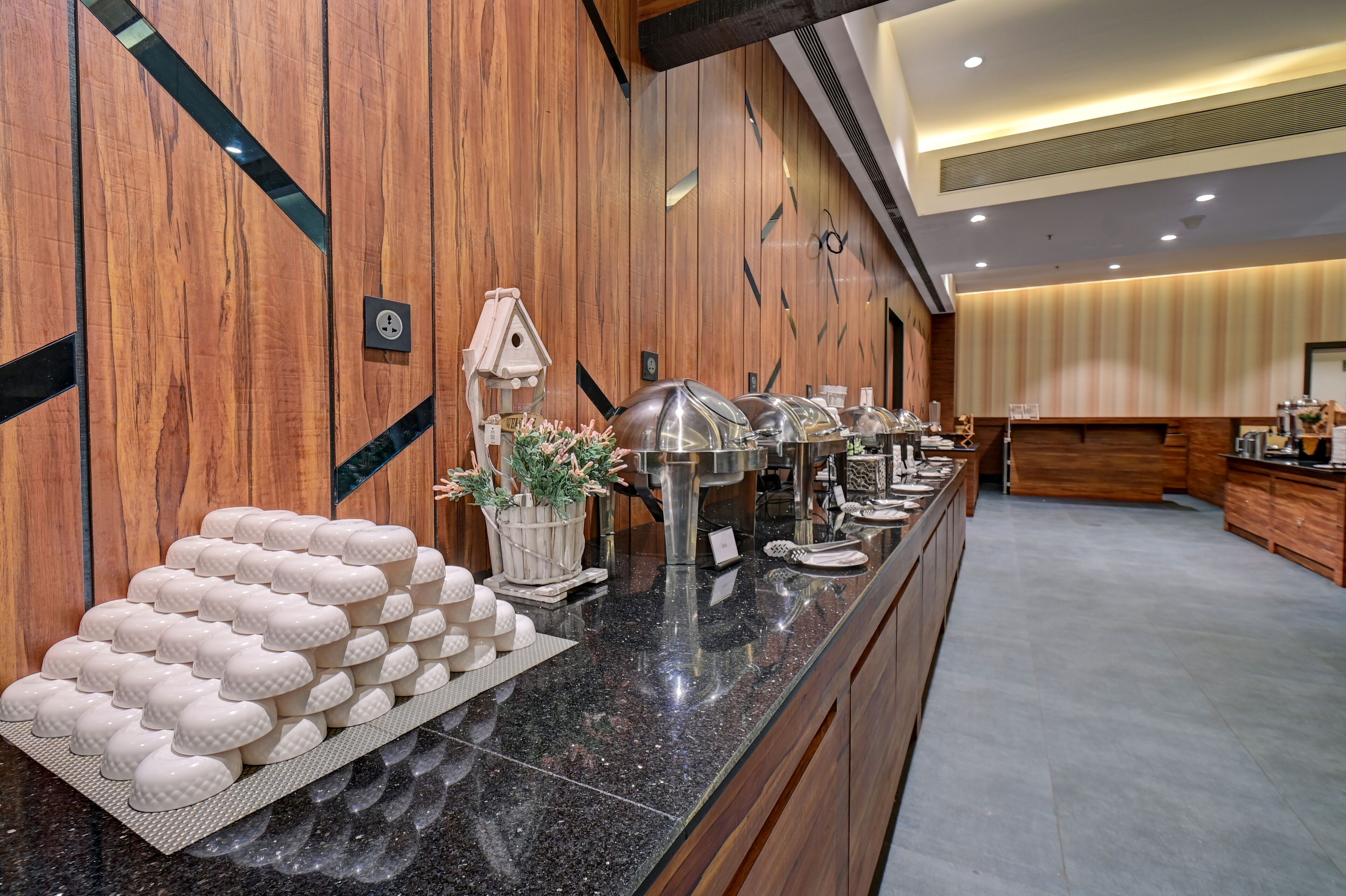 Una mesa de buffet con diferentes recipientes de comida y una casa de pájaros decorativa.