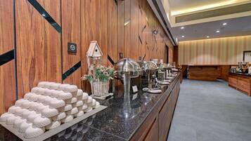 Una mesa de buffet con diferentes recipientes de comida y una casa de pájaros decorativa.