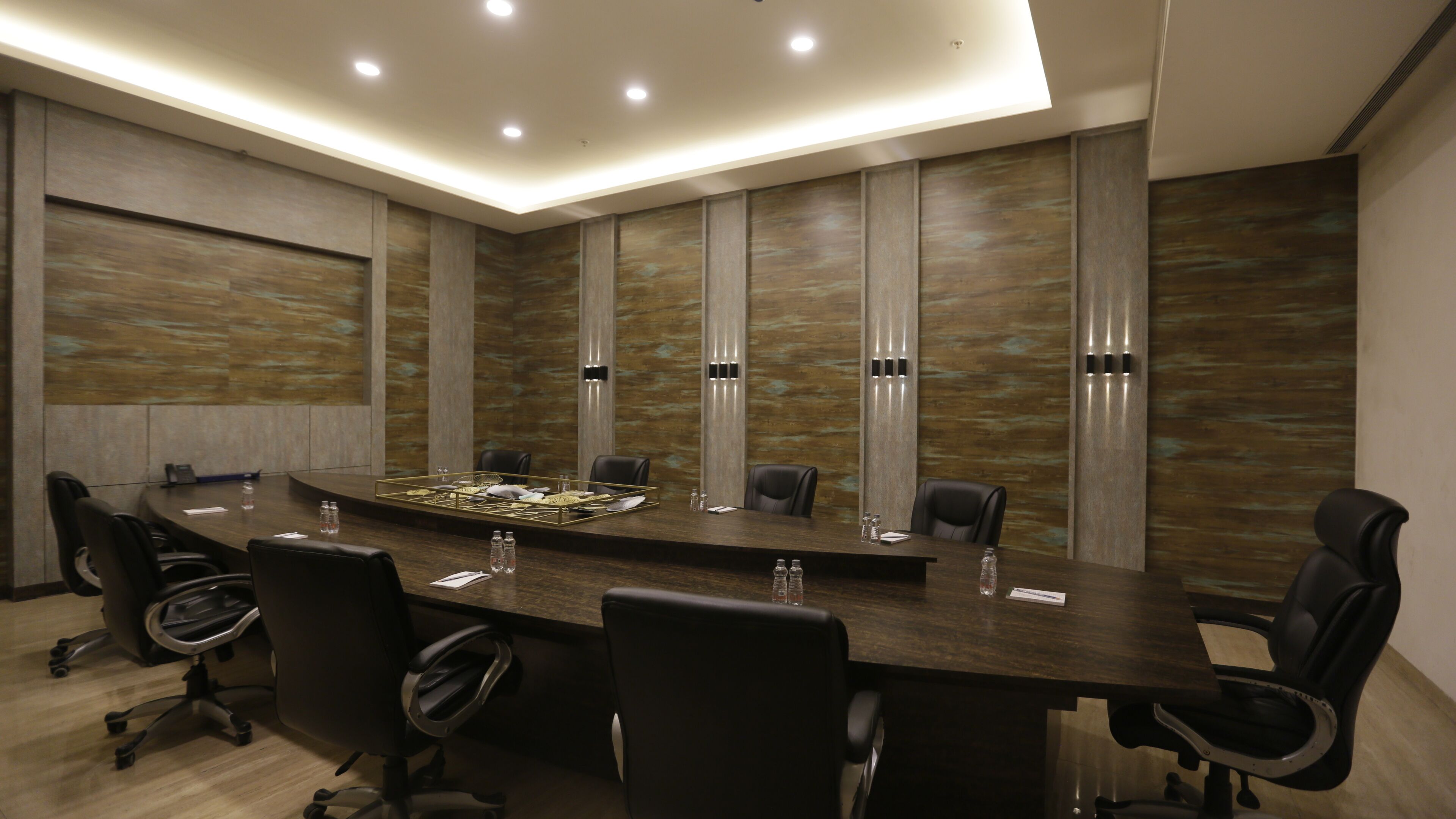 A conference room with a long table, black chairs, and a modern design.